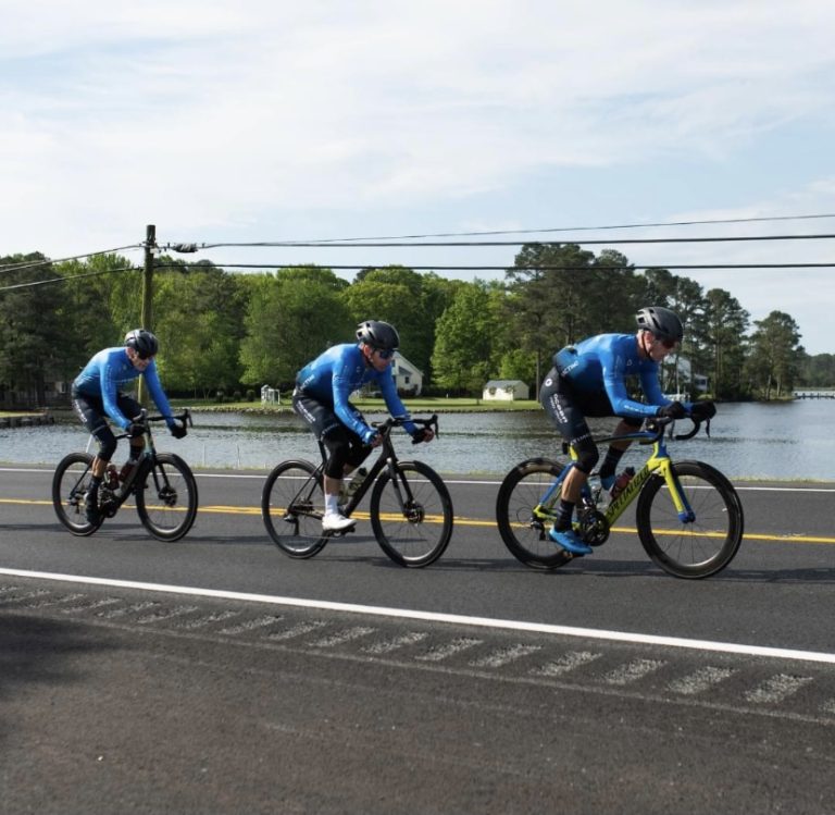 Male bikers cycling by water